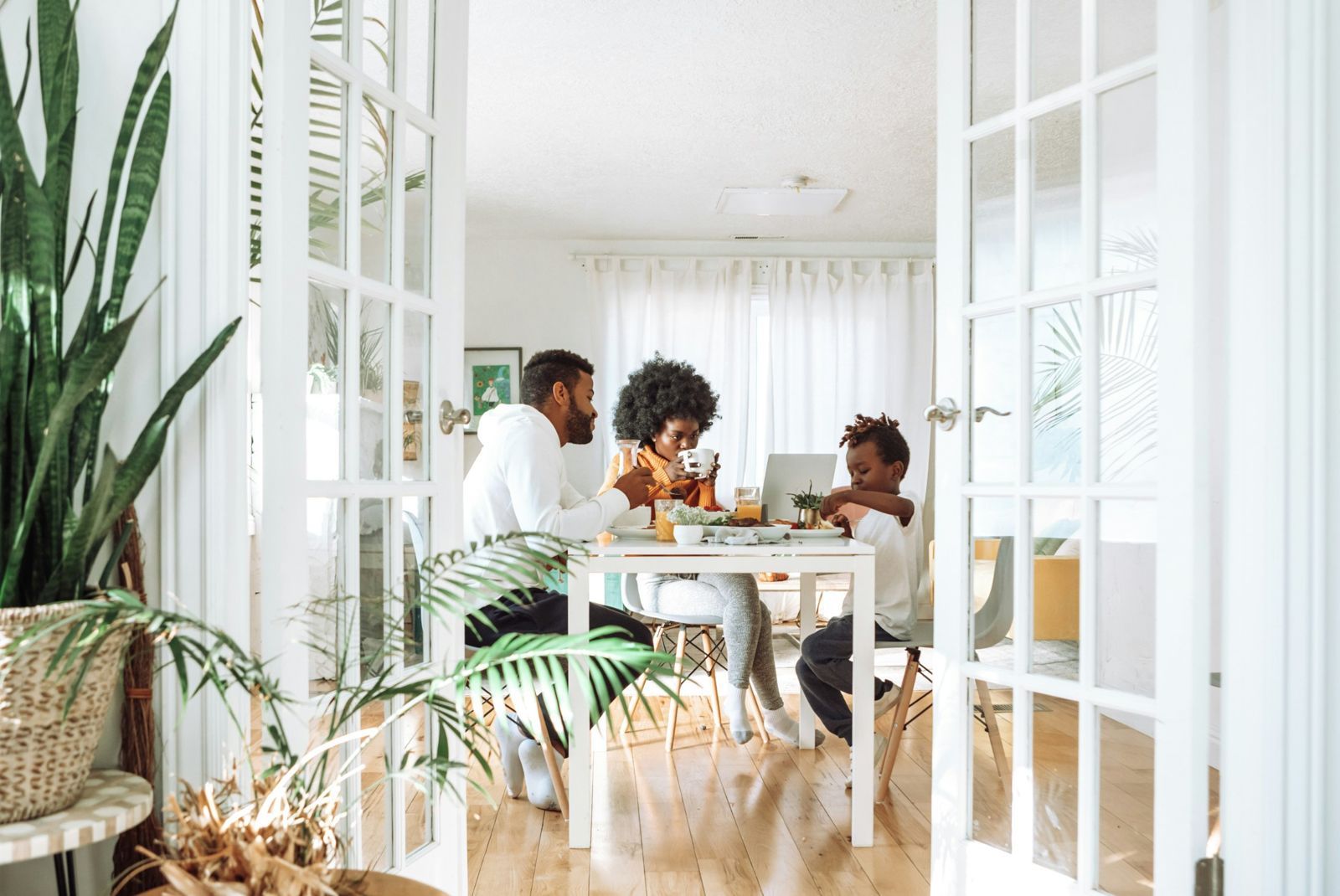 A family eating breakfast together in a sunny dining room