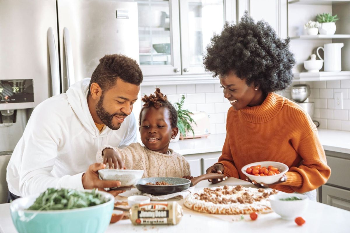 A family making pizza together in the kitchen